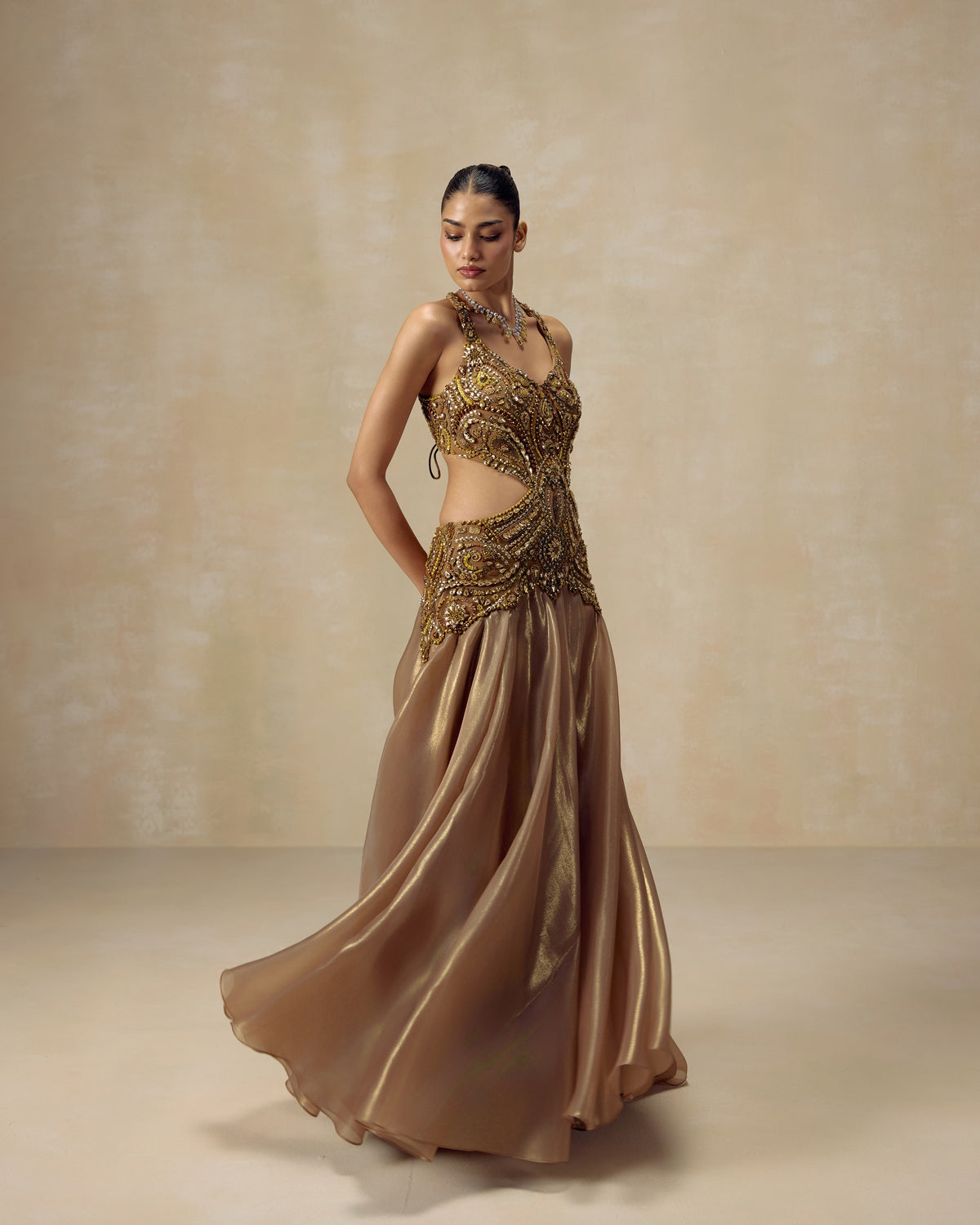 Gold luminous organza backless gown with halter neck and hand-embroidered crystal and stone Persian motifs — RINESSA